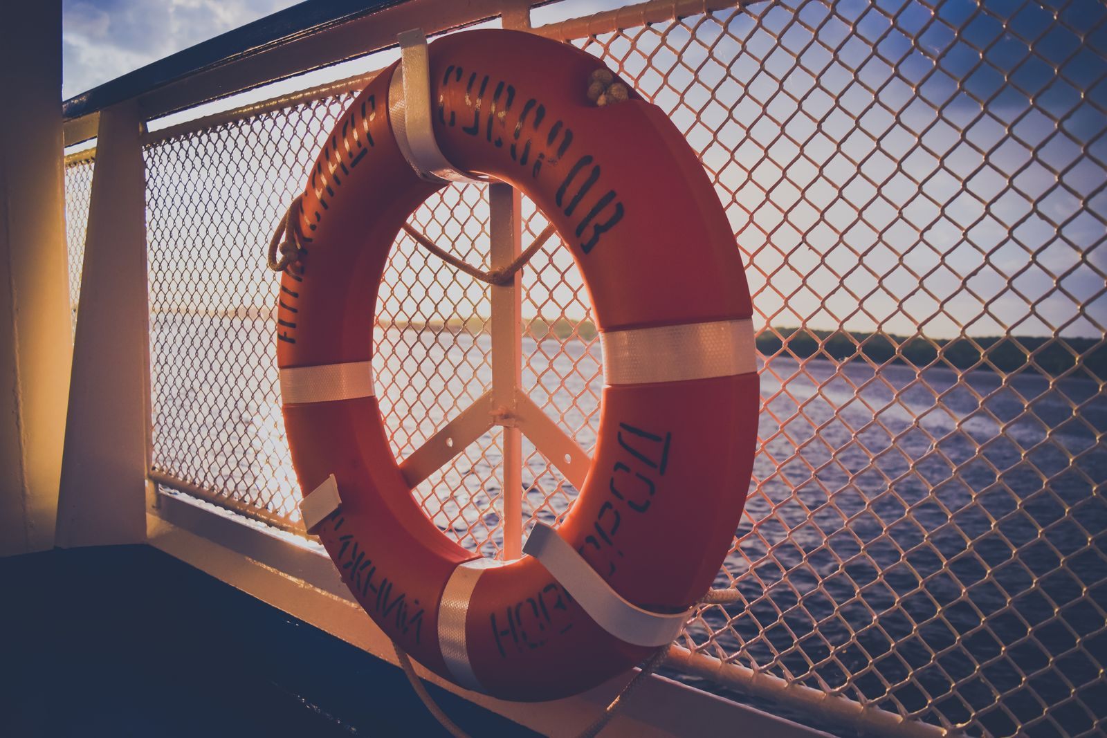 Lifebuoy on a ship deck railing at sunset, a reminder of simple cruise safety tips