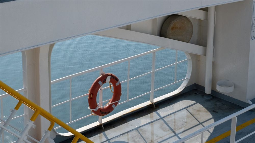 Life ring hanging on a ship deck overlooking the calm sea